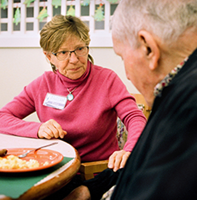 Older adult caregiver speaks with patient